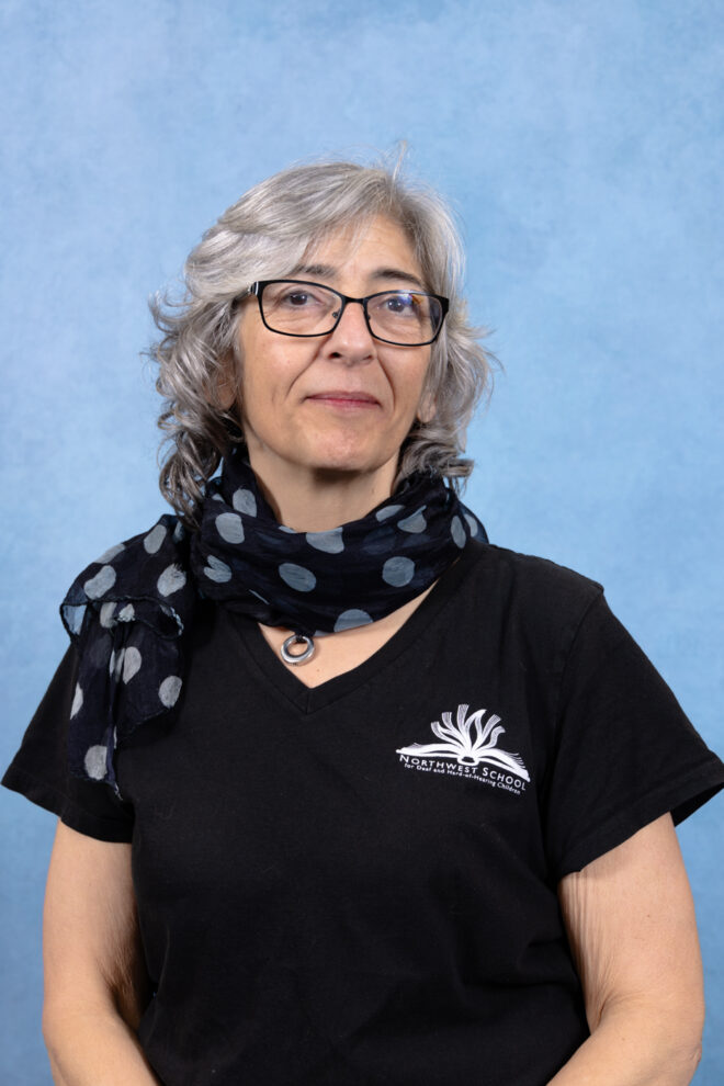 Linda Penwell smiles at the camera in front of a blue background